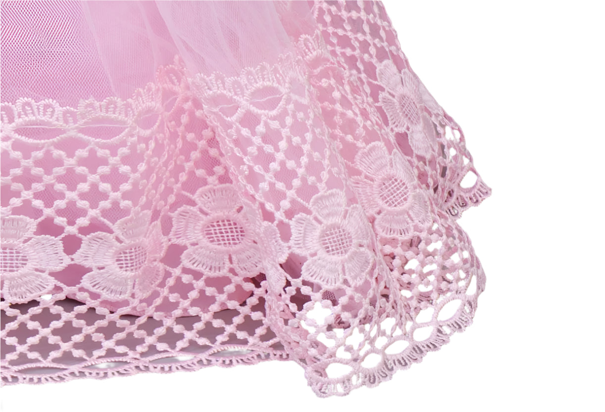 Close-up of pink fabric with white lace trim on a gray background